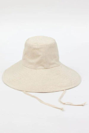 The LIVVY CANVAS SUN HAT from Velvet by Graham & Spencer, a wide-brimmed light beige fabric hat with adjustable strings, rests on a plain white surface.