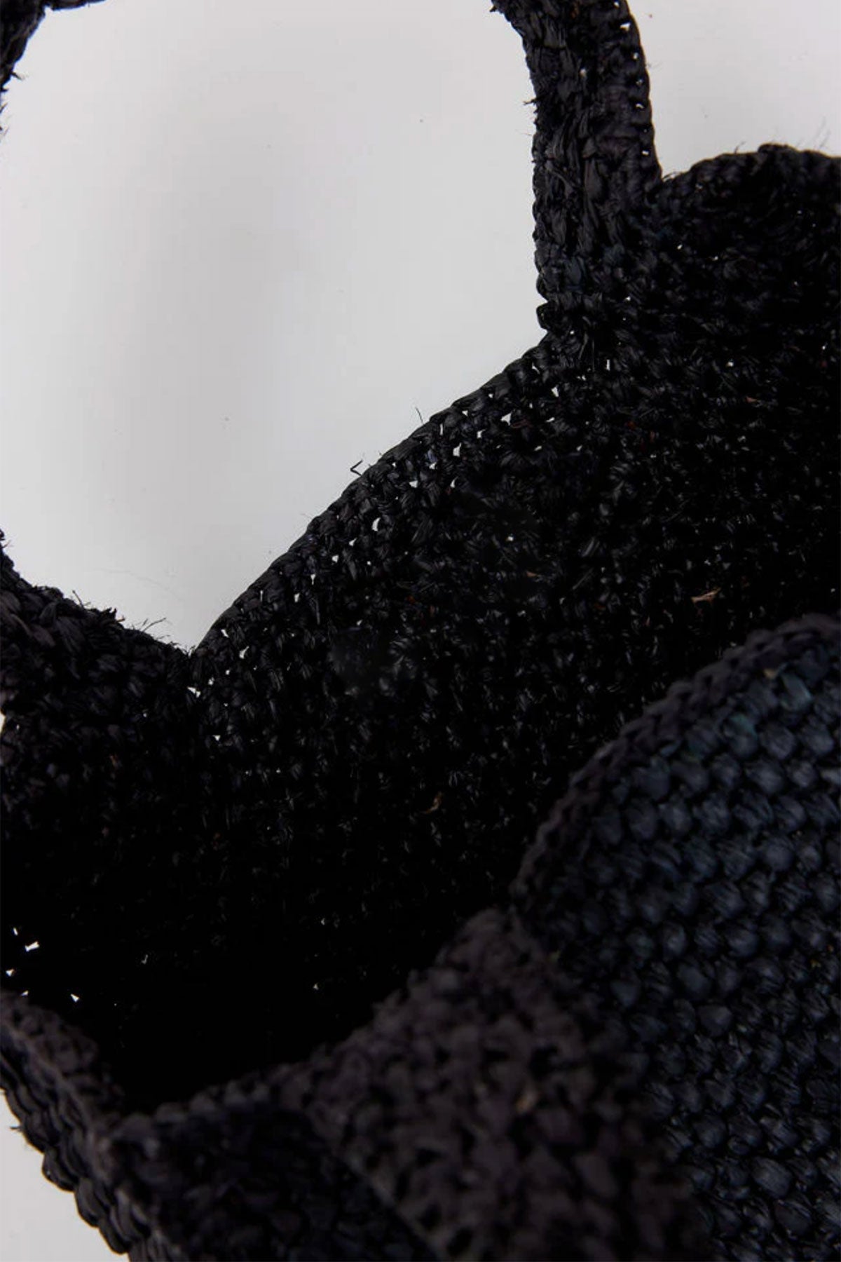 Close-up of the MINI LULU TOTE, a black woven basket by Velvet by Graham & Spencer, featuring two handles against a plain background.-38884405805249