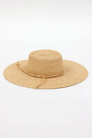 The SADIE SUN HAT by Velvet by Graham & Spencer is a wide-brimmed straw hat featuring a flat crown and a decorative string, set against a plain white background.