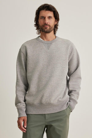 A man is wearing the HAMES SWEATSHIRT by Velvet by Graham & Spencer alongside olive green pants, set against a plain background.