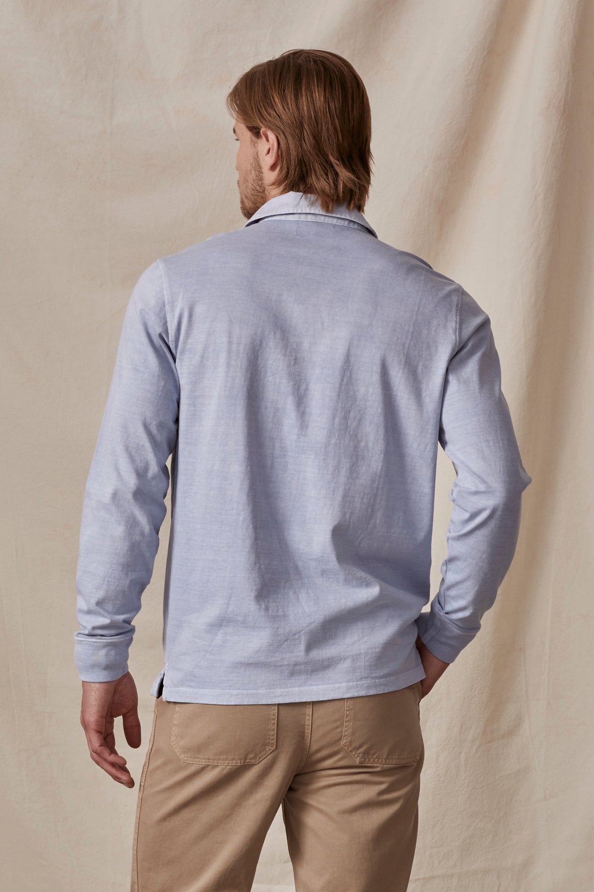   The back of a man wearing a Velvet by Graham & Spencer BALTHAZAR HEAVY JERSEY POLO and tan pants. 