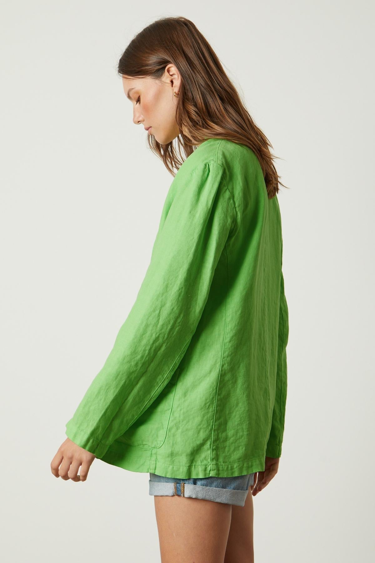 The side view of a woman wearing a Velvet by Graham & Spencer CASSIE HEAVY LINEN BLAZER.