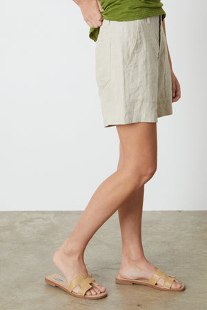 a woman wearing a green shirt and Velvet by Graham & Spencer's FALLON HEAVY LINEN SHORT.
