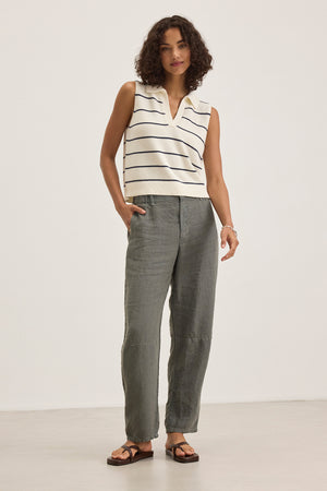 A person with curly hair wears a sleeveless striped top and the TAYLOR HEAVY LINEN PANT by Velvet by Graham & Spencer, paired with sandals, against a plain background.