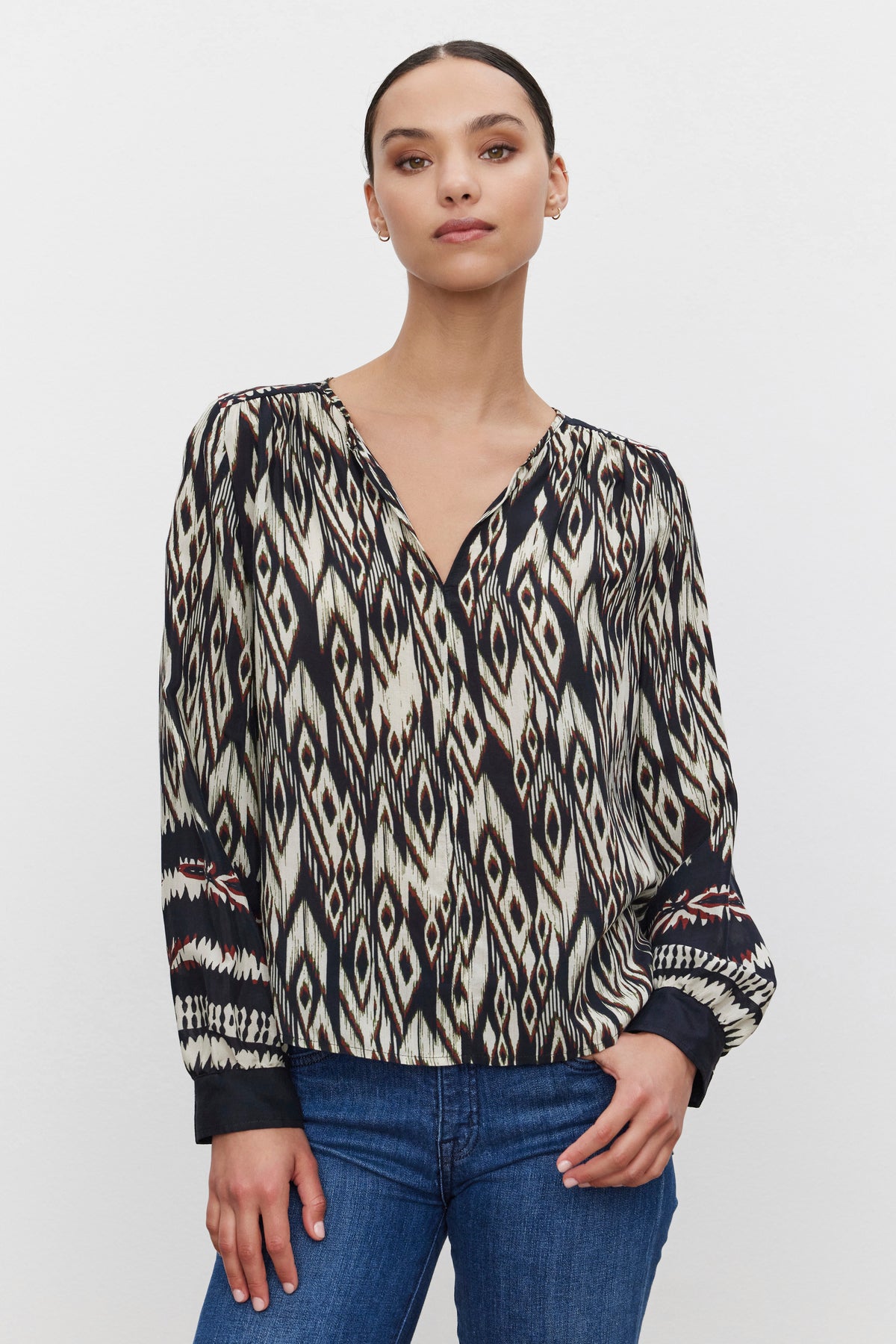 A person wearing the ABRIELLE TOP from Velvet by Graham & Spencer, paired with blue jeans, stands against a plain white background.-38372840636609
