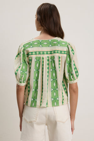 A person is shown from the back wearing the short-sleeved, green and cream MARISSA TOP by Velvet by Graham & Spencer, a cotton jacquard blouse with vertical stripes, paired with white high-waisted shorts.
