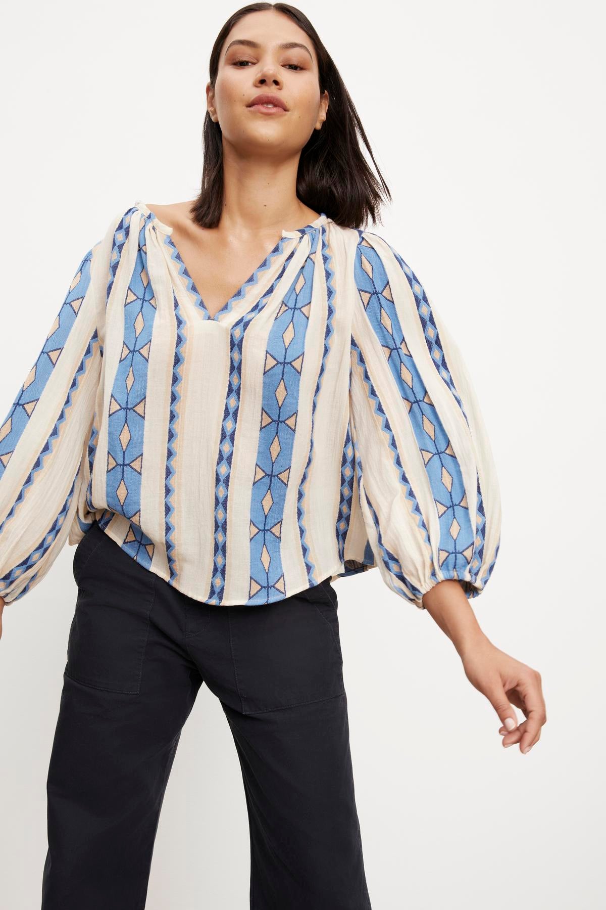 The model is wearing a Velvet by Graham & Spencer NANNI JACQUARD V-NECK BLOUSE.-35702114975937