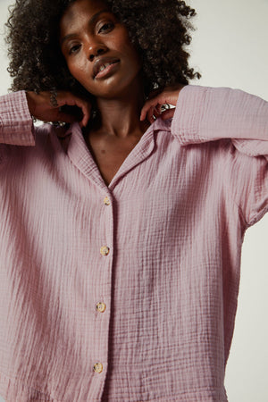 The model is wearing a pink PJAMA SHIRT with buttons from Jenny Graham Home.