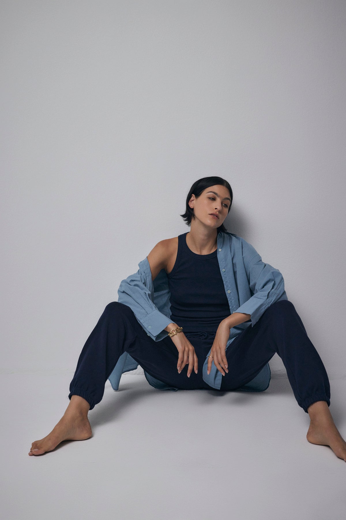   A woman sitting on the floor in a Velvet by Jenny Graham WESTLAKE SWEATPANT and blue shirt. 
