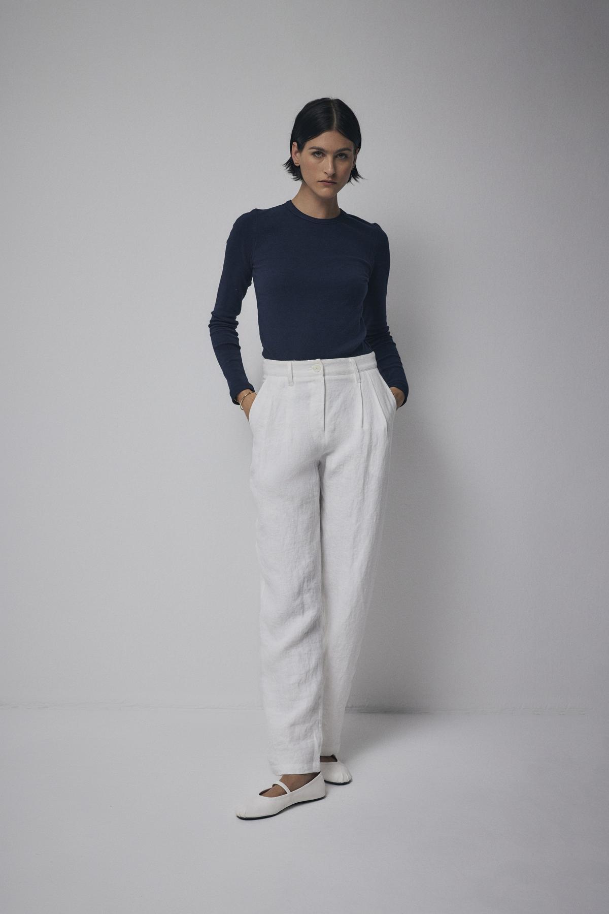 A person standing in a neutral pose wearing a Velvet by Jenny Graham CAMINO TEE, white trousers, and white flat shoes against a plain background.-36463422111937