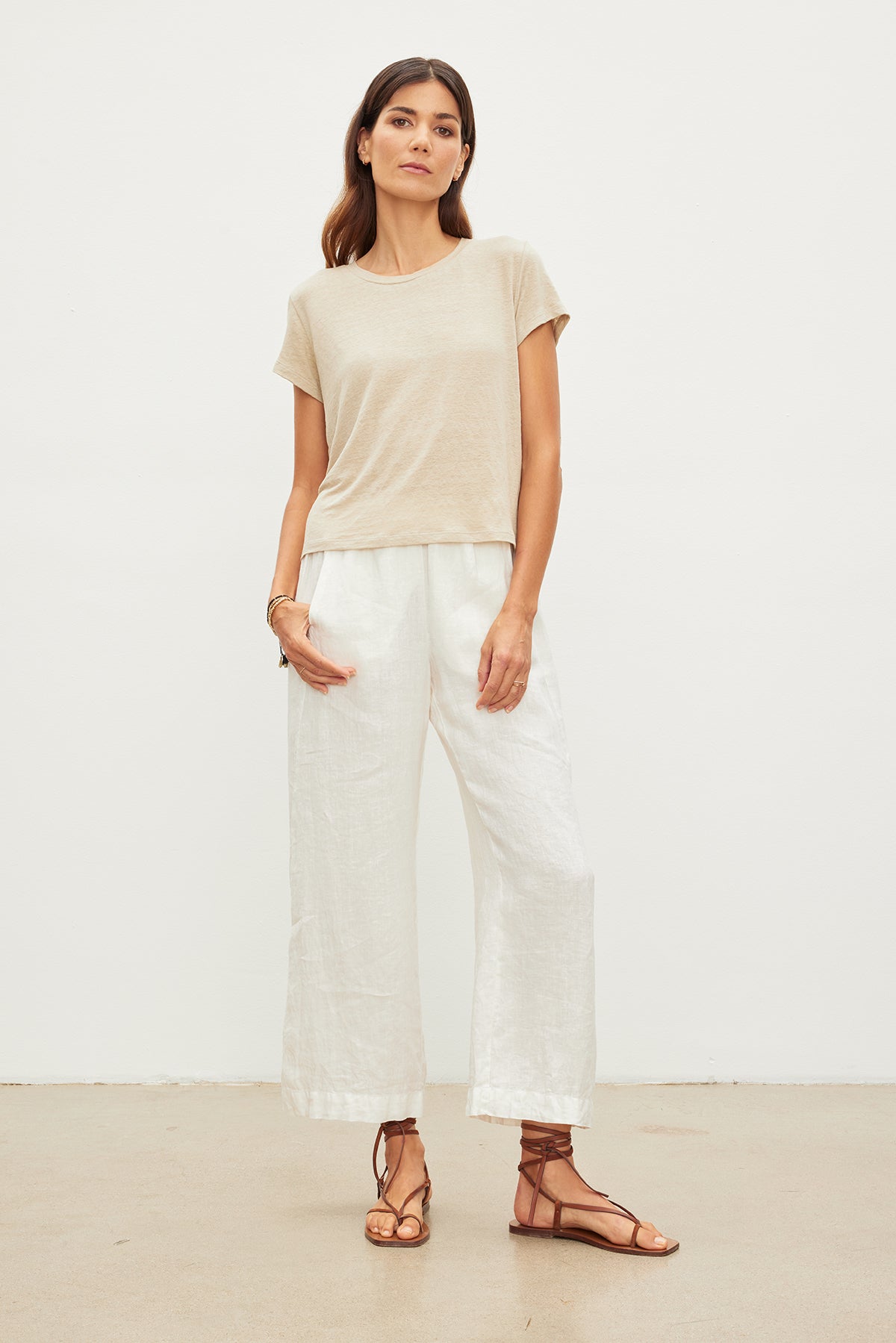 The model is wearing a must-have Velvet by Graham & Spencer Casey Linen Knit Crew Neck Tee and white linen pants.-35955506020545