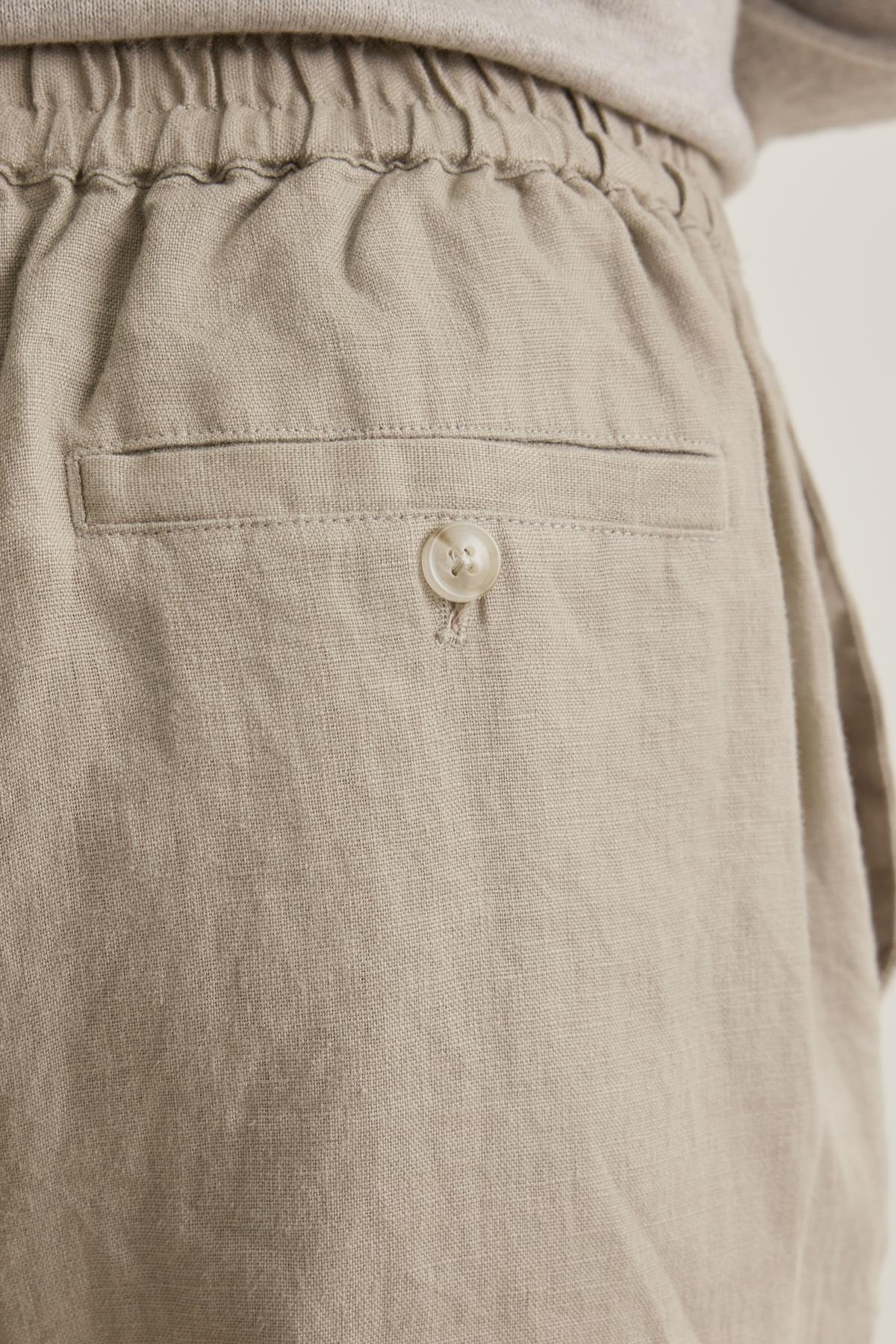 Close-up of LENNON LINEN PANT by Velvet by Graham & Spencer: Beige with a textured look, features an elastic waistband and a button-closure back pocket.-38643401720001