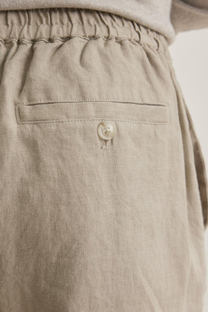 Close-up of LENNON LINEN PANT by Velvet by Graham & Spencer: Beige with a textured look, features an elastic waistband and a button-closure back pocket.