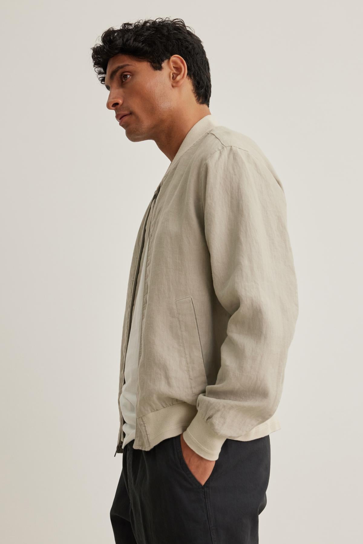 A man is wearing a MURPHY LINEN BOMBER JACKET from Velvet by Graham & Spencer over a white shirt, facing left against a plain background.