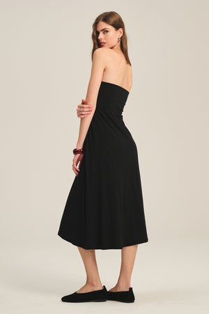 Woman wearing the LUELLA SKIRT by Velvet by Graham & Spencer, styled with black flat shoes, stands sideways and looks over her shoulder against a plain background.