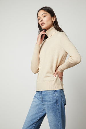 The model is wearing a Velvet by Graham & Spencer SALLY MOCK NECK SWEATER.
