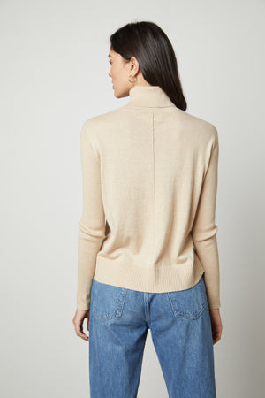 The back view of a woman wearing a Velvet by Graham & Spencer SALLY MOCK NECK SWEATER.