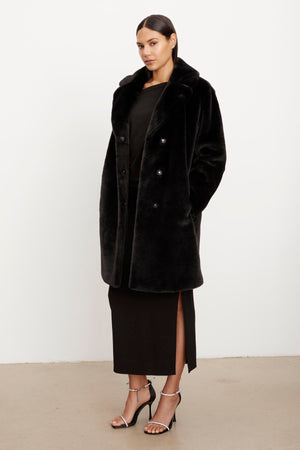 The model is wearing a Velvet by Graham & Spencer EVALYN LUX FAUX FUR COAT.