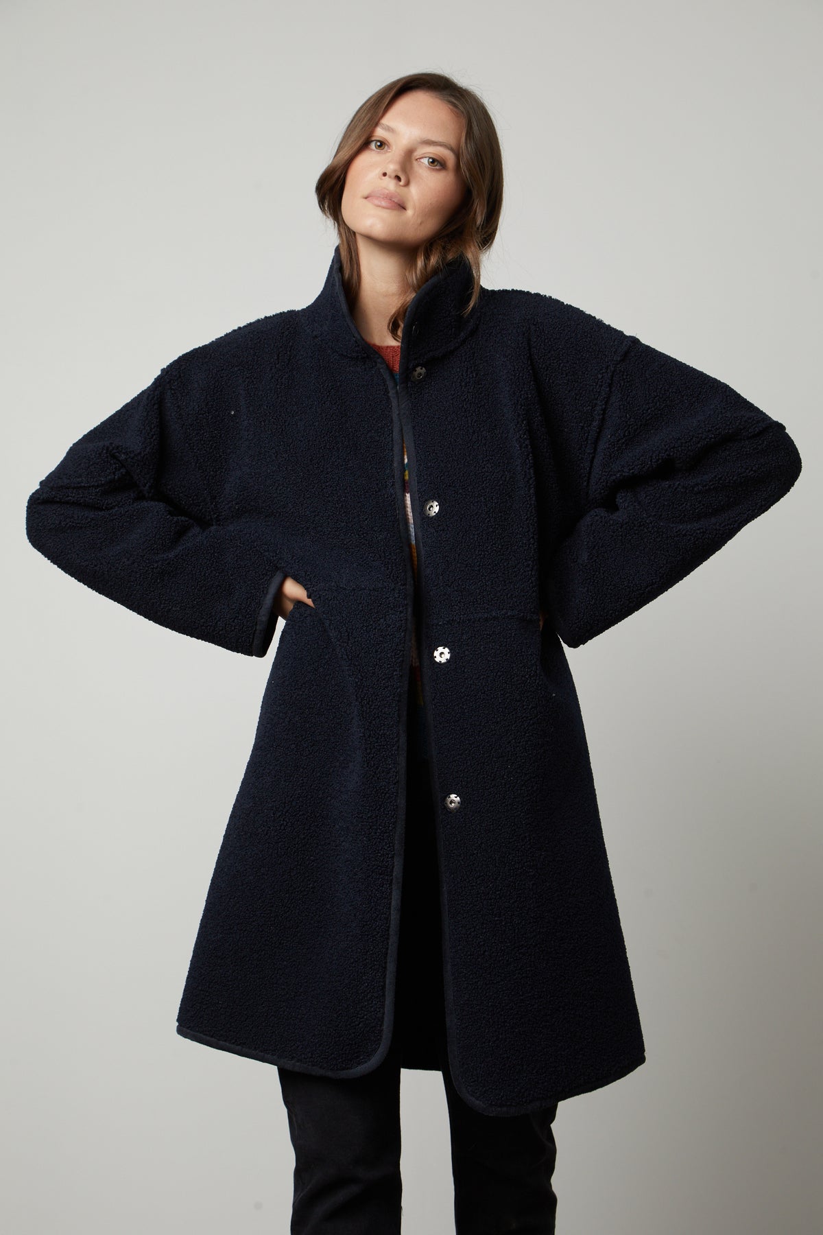 A woman wearing a Velvet by Graham & Spencer CARA LUX SHERPA REVERSIBLE JACKET and black pants.-26897578754241