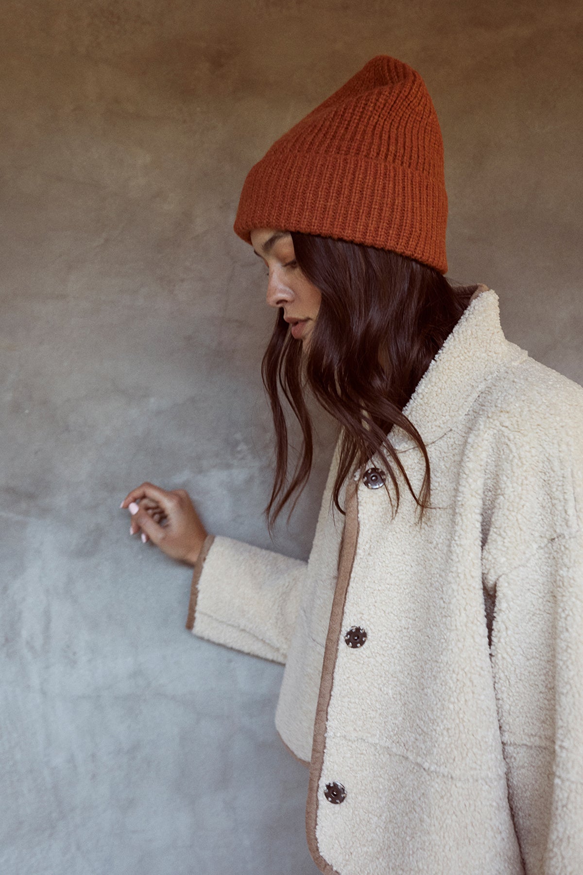A woman wearing a beanie and jeans in a Velvet by Graham & Spencer KELLY LUX SHERPA REVERSIBLE JACKET.