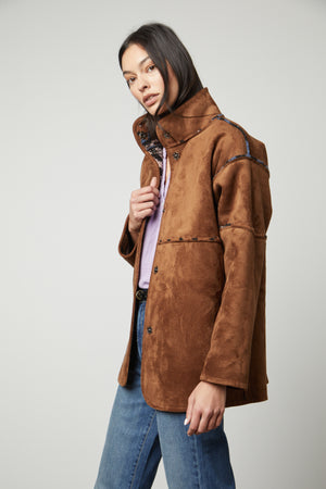 A model wearing a Velvet by Graham & Spencer LAILA PRINTED SHERPA REVERSIBLE JACKET and jeans.