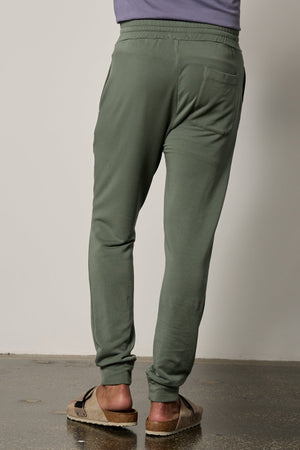 The back view of a man wearing Crosby Luxe Fleece Jogger sweatpants from Velvet by Graham & Spencer, suitable for workouts and made of fleece knit.