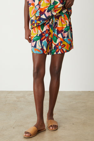 A woman wearing Velvet by Graham & Spencer's JOSIE PRINTED LINEN SHORT and sandals.