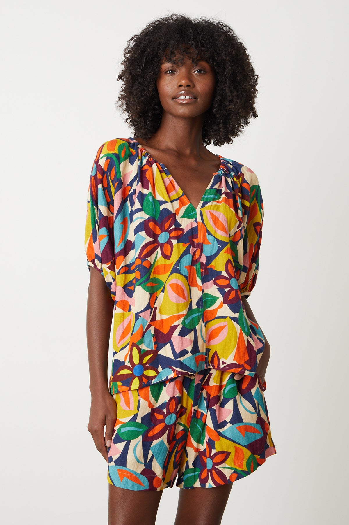A woman wearing a Velvet by Graham & Spencer ROBIN PRINTED LINEN TOP and shorts.