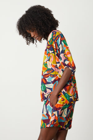 A woman wearing a Velvet by Graham & Spencer ROBIN PRINTED LINEN TOP and shorts.