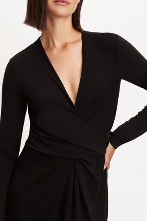 The model is wearing a ELIANA WRAP MIDI DRESS with long sleeves.