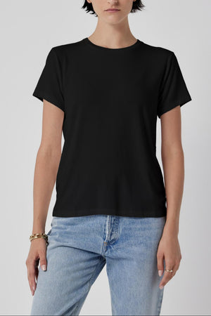 Woman in a classic Velvet by Jenny Graham SOLANA TEE and blue jeans standing against a plain background.