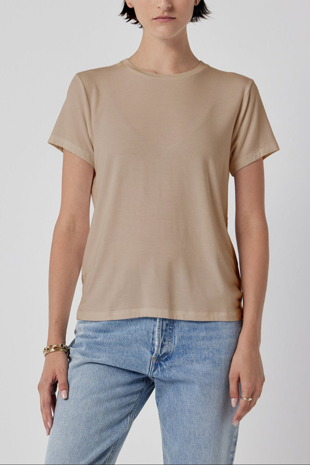 Woman modeling a classic Solana Tee by Velvet by Jenny Graham in beige and blue jeans against a white background.-36290532344001