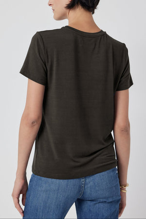 Woman wearing a plain SOLANA TEE in olive green from Velvet by Jenny Graham and blue jeans viewed from the back.