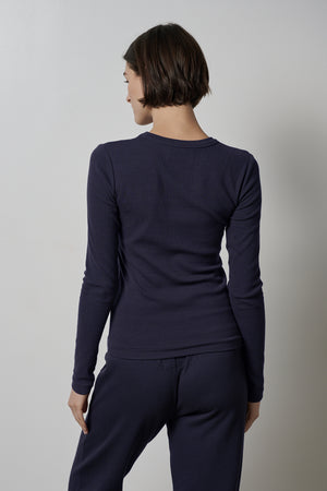 The back view of a woman wearing a Velvet by Jenny Graham CAMINO TEE and pants, providing ultimate comfort with a slimmer fit.