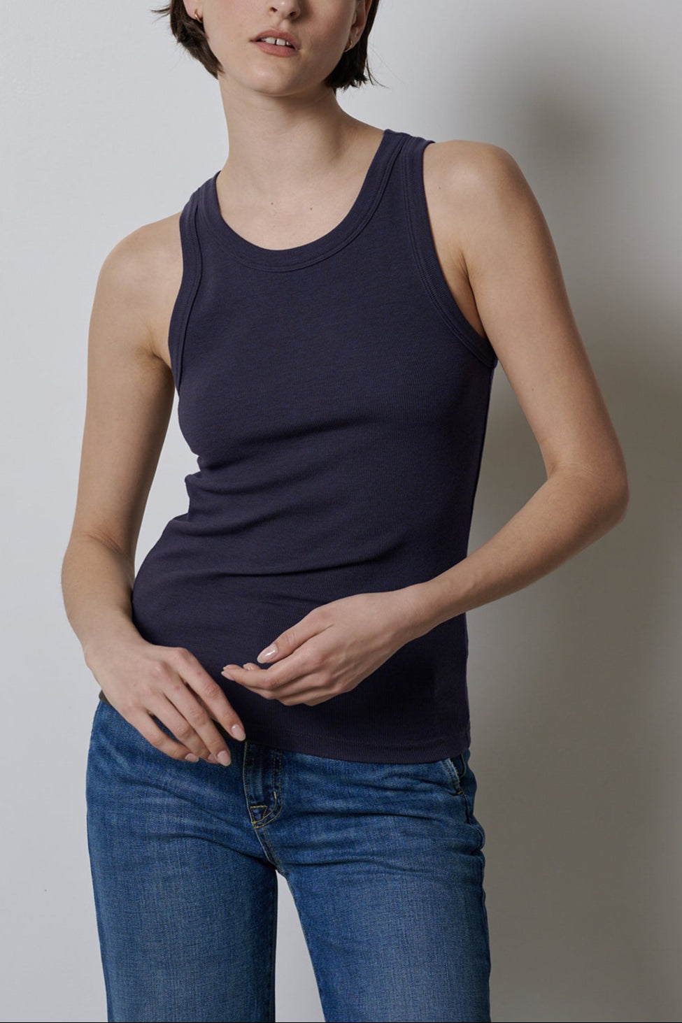 A woman wearing stretch jeans and a fitted Navy Velvet by Jenny Graham Cruz tank top.