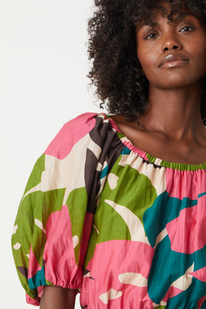 a woman wearing a Velvet by Graham & Spencer BRITNEY PRINTED CROPPED BOHO TOP with a camouflage print.