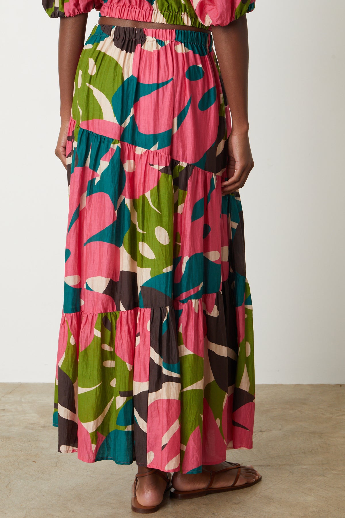 The back view of a woman wearing a Velvet by Graham & Spencer LYDIA PRINTED TIERED SKIRT.-26514115264705