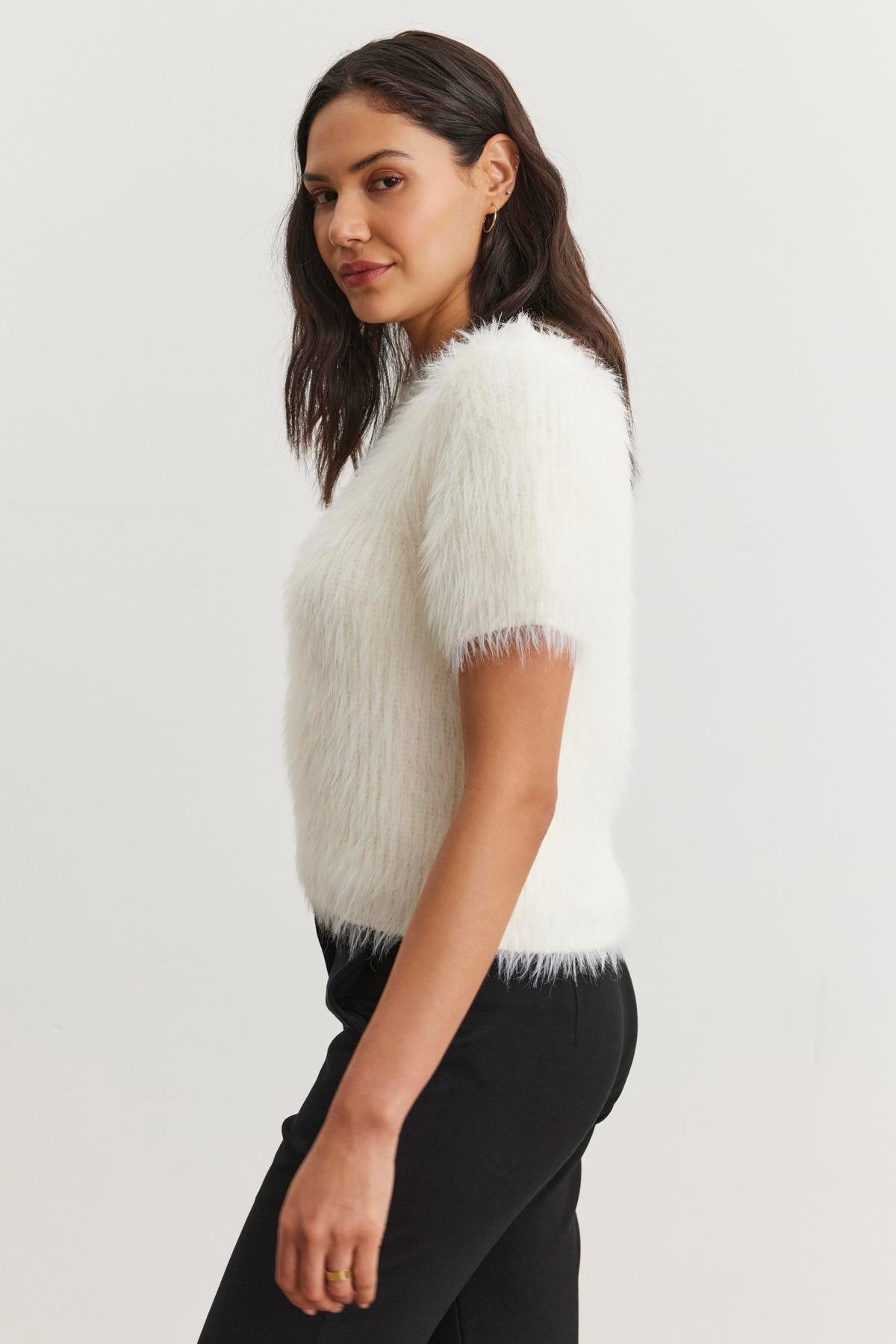A woman wearing the EILA FEATHER YARN SWEATER by Velvet by Graham & Spencer, paired with black pants, stands in a neutral pose against a plain background.-38246411600065