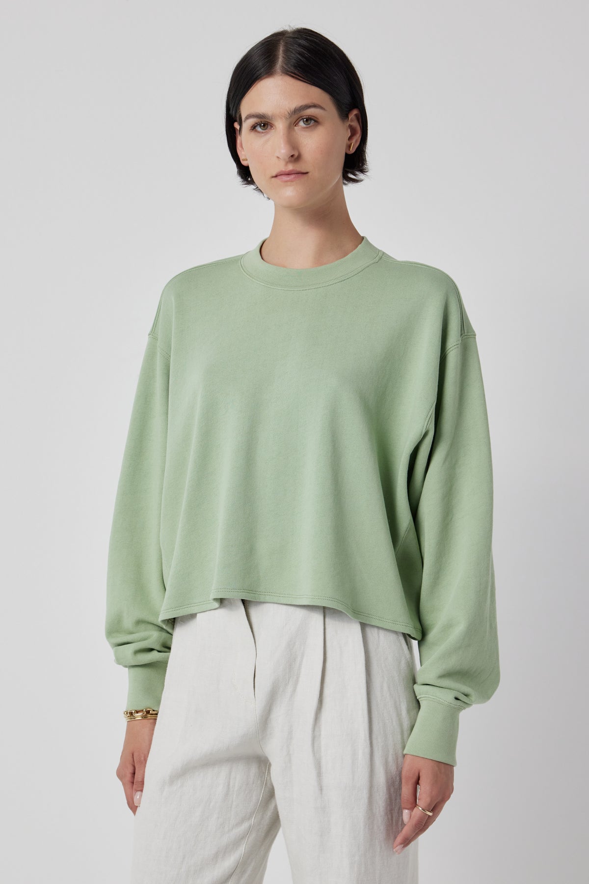 A model wearing a green Velvet by Jenny Graham MALIBU SWEATSHIRT and white pants.-36168705343681
