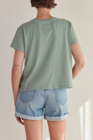 the back view of a woman wearing denim shorts and a Velvet by Jenny Graham TOPANGA TEE.