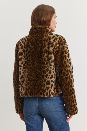 A person is wearing the VALLI FAUX FUR JACKET by Velvet by Graham & Spencer, paired with blue jeans, facing away.