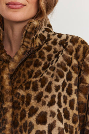 Close-up of a person wearing the VALLI FAUX FUR JACKET by Velvet by Graham & Spencer, highlighting the fabric texture and leopard-print pattern.