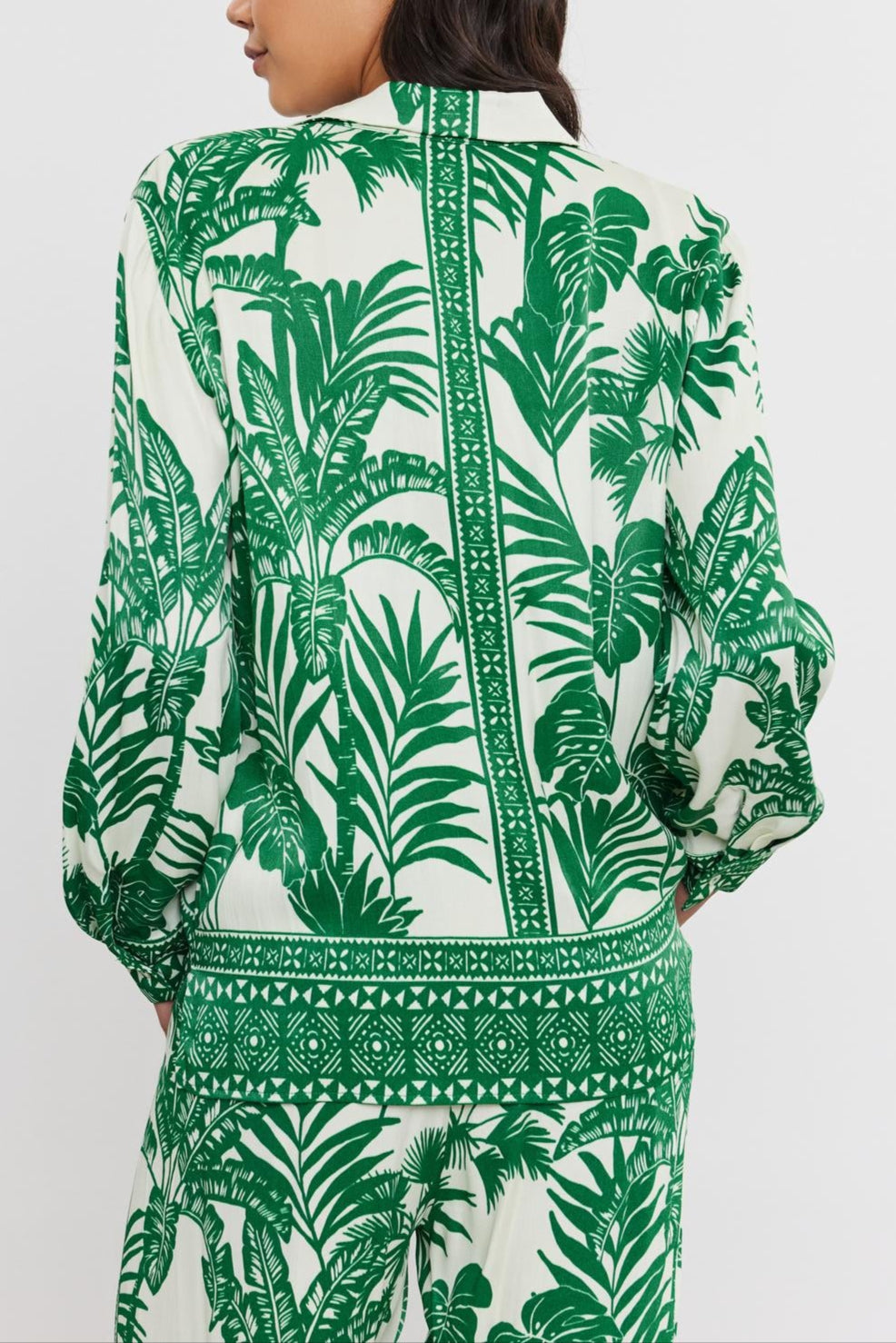 Woman seen from the back wearing a white and green palm print AYLA BUTTON-UP SHIRT with long sleeves, standing against a plain background. Brand name: Velvet by Graham & Spencer-36910265172161