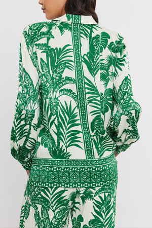 Woman seen from the back wearing a white and green palm print AYLA BUTTON-UP SHIRT with long sleeves, standing against a plain background. Brand name: Velvet by Graham & Spencer
