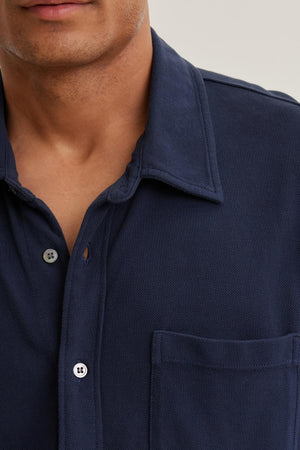 Individual in a chest-upshot, wearing the GIORGIO PIQUE BUTTON-UP SHIRT by Velvet by Graham & Spencer in navy blue, featuring a pocket.