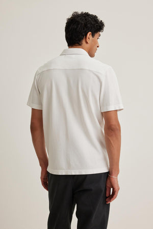 Person wearing a MARTYN PIQUE BUTTON-UP SHIRT by Velvet by Graham & Spencer, with dark pants, facing away.