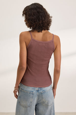 A person with curly hair wears the INIKU POINTELLE TANK TOP by Velvet by Graham & Spencer, a sleeveless ribbed brown top in a soft cotton modal blend, paired with light blue jeans and shown from the back against a plain background.