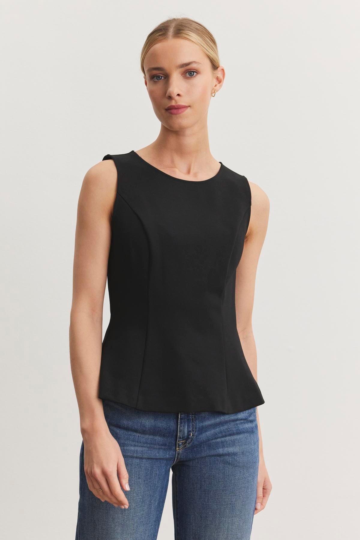 A person wears the FELICITEE PONTE TOP by Velvet by Graham & Spencer, paired with blue jeans, standing against a light background.