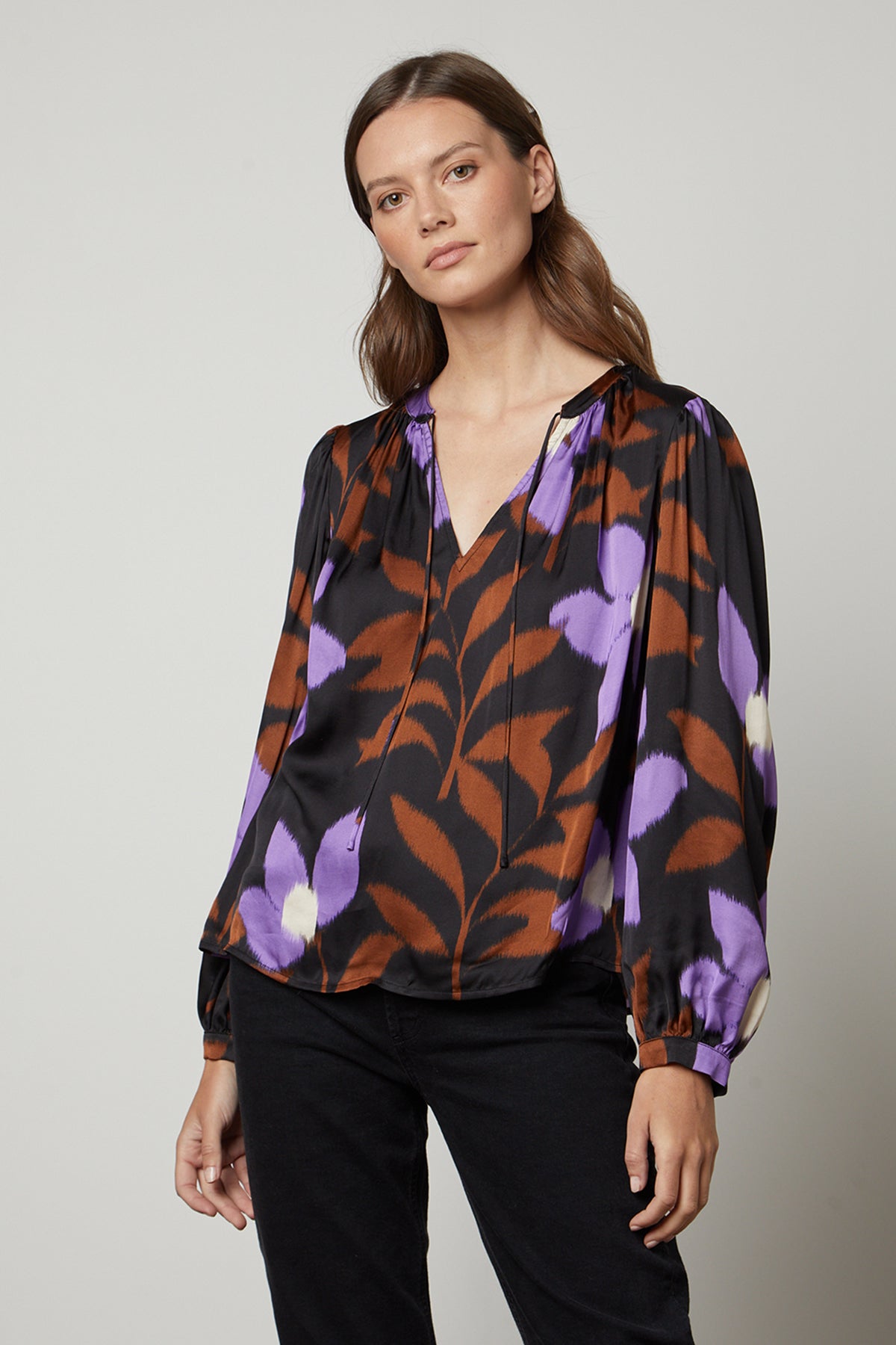 A woman wearing an ISRA printed V-neck blouse by Velvet by Graham & Spencer.-35503646245057