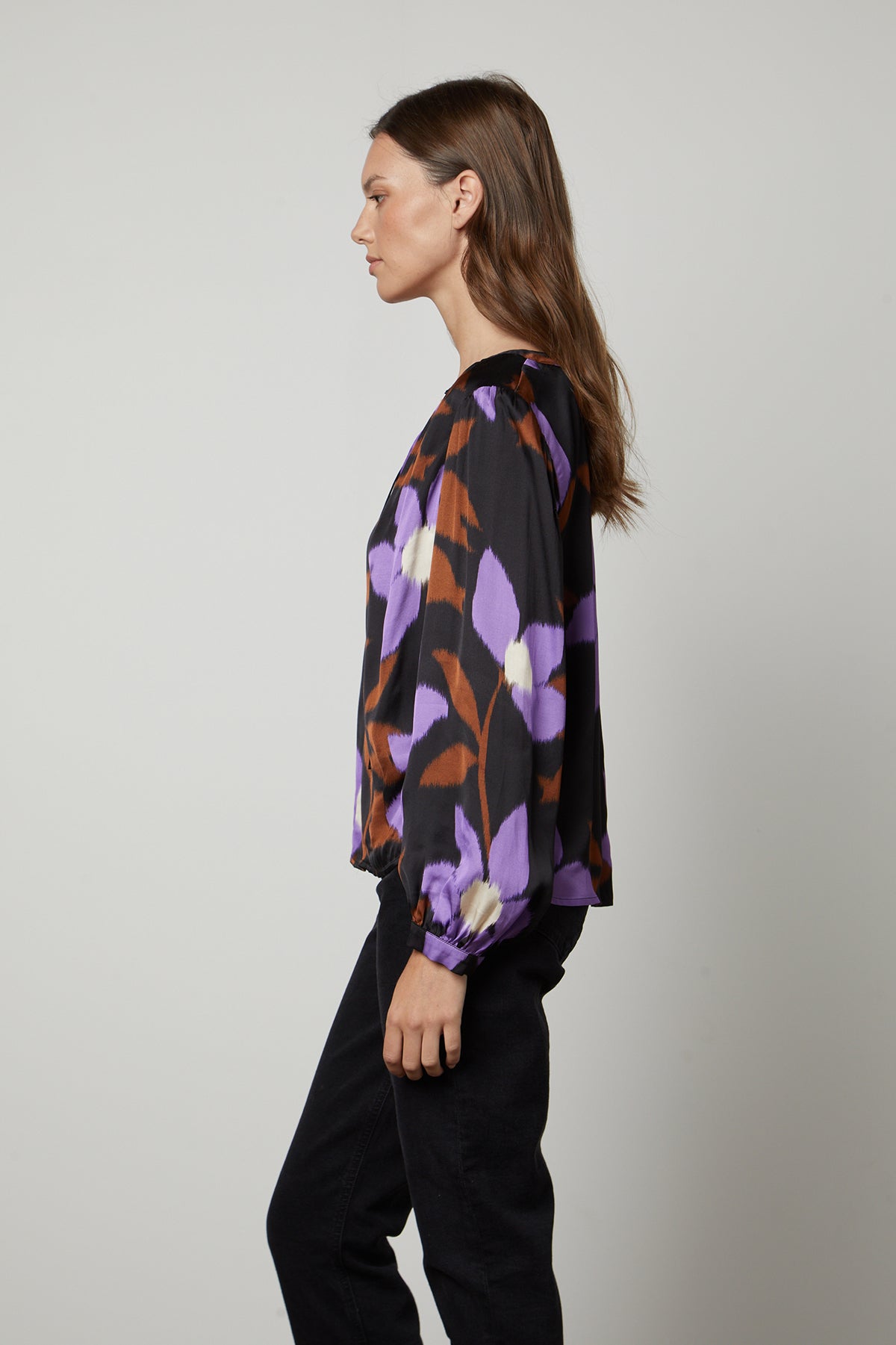 A woman wearing the Velvet by Graham & Spencer ISRA PRINTED V-NECK BLOUSE in purple and black.-35503651324097